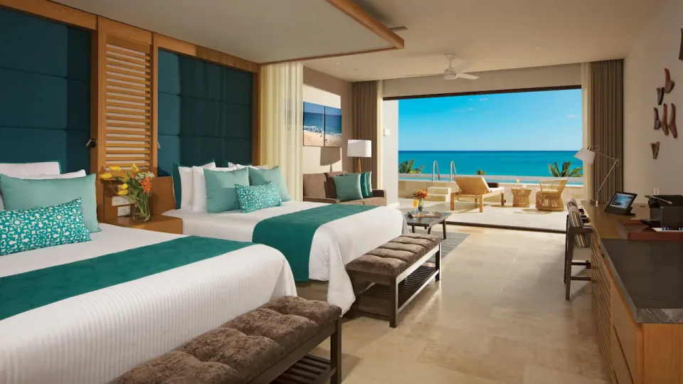 Identical file to hero.webp: two-queen suite opening onto a terrace with pool ladder and ocean view (not a two-room family suite)