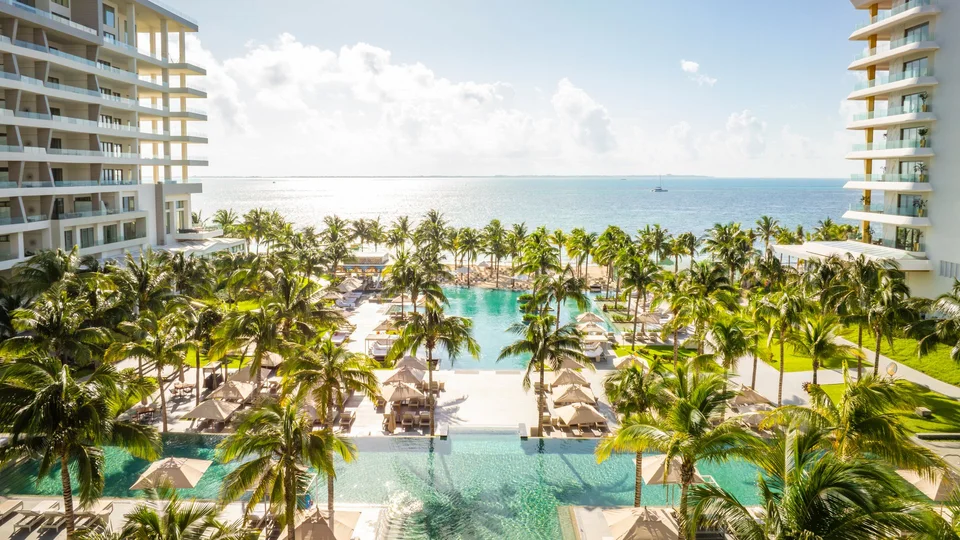 Identical file to media/originals/hotels/garza-blanca-cancun/hero.jpg (towers, pools, palms, flat beach); the file name's 'cliff' and 'cove' are false