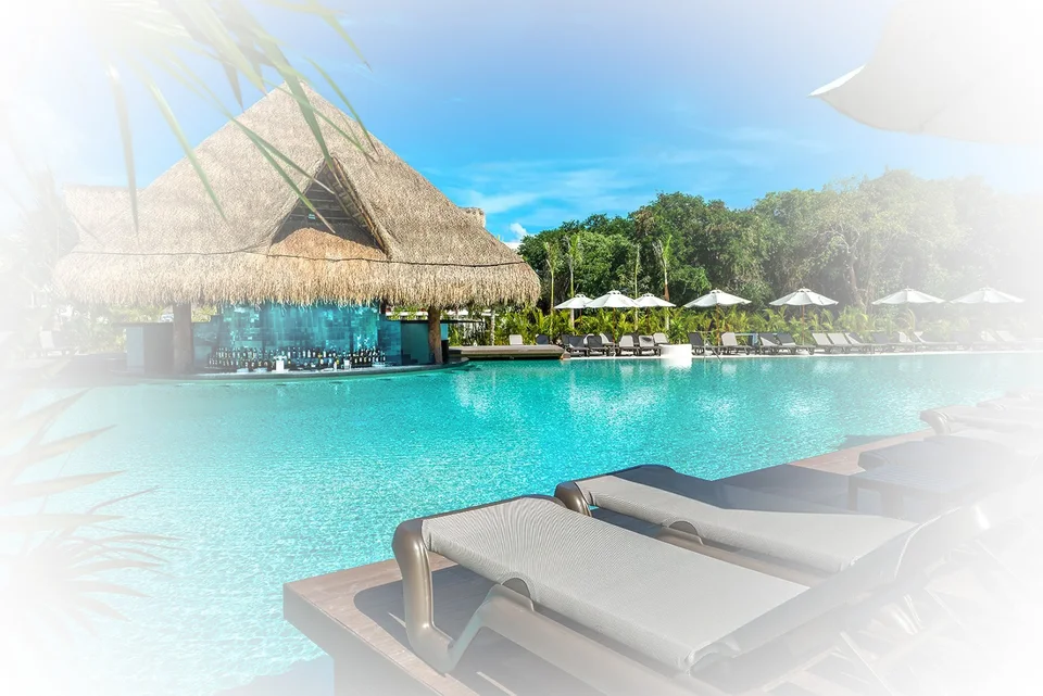 Same pool and palapa swim-up bar as the .webp, with a heavy white vignette added around the edges. Identical to media/originals/hotels/ocean-riviera-paradise/hero.jpg.