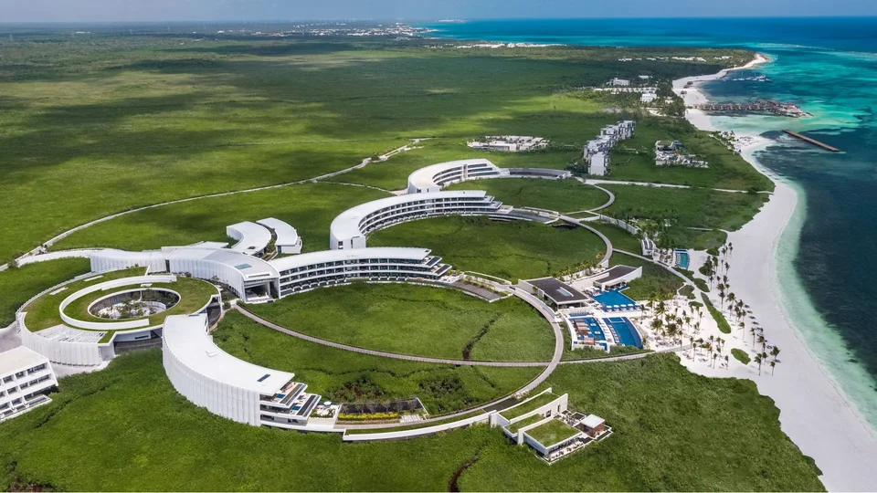 Same aerial of the Pleiades-inspired crescent buildings, mangroves, pools and beach